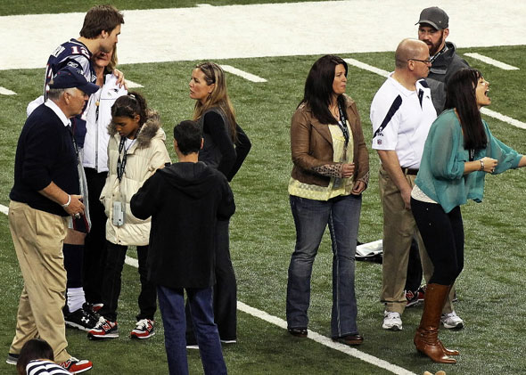 Kevin Youkilis (top right) with the Brady family, including Tom's three sisters and his parents on the field at Lucas Oil Stadium the day before the Super Bowl
