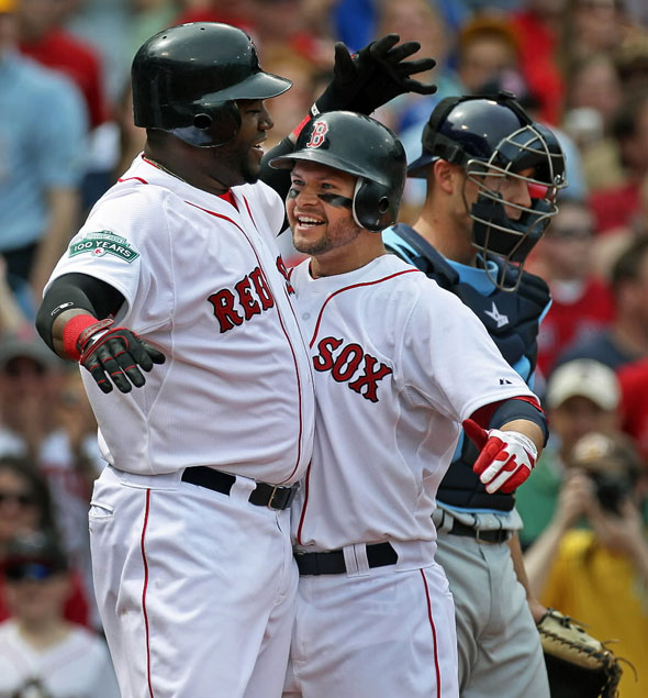 The Red Sox Cody Ross is welcomed home by teammate David Ortiz following his second inning three run home run that put Boston ahead 3-0. The Boston Red Sox hosted the Tampa Bay Rays in an MLB game at Fenway Park.