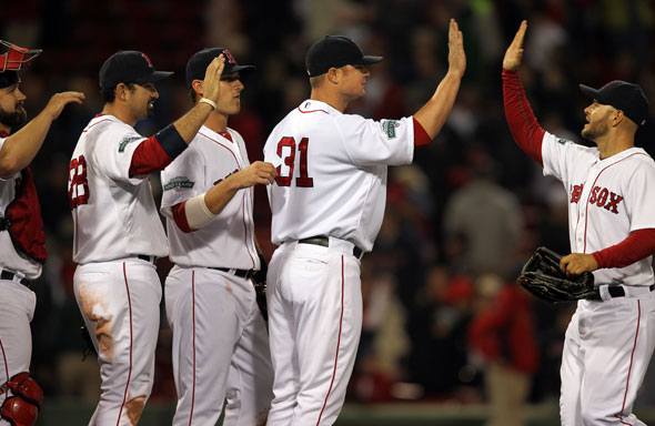 Red Sox starting pitcher Jon Lester celebrates with teamates after throwing a complete game victory. Cody Ross at right.