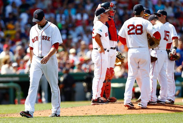 Jon Lester of the Boston Red Sox walks to the dugout after being pulled by manager Bobby Valentine #25 in the fifth inning against the Toronto Blue Jays during the game on July 22, 2012 at Fenway Park in Boston
