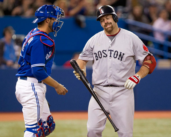 Boston Red Sox Kevin Youkilis, right, reacts in front of Toronto Blue Jays catcher J.P. Arencibia after striking out during ninth inning of a baseball game in Toronto on Wednesday, April 11, 2012.