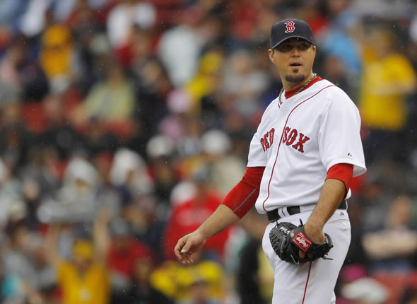 Red Sox pitcher Josh Beckett waits while the umpires review a call in the second inning of their MLB American League baseball game against the Seattle Mariners at Fenway Park in Boston, Massachusetts May 15, 2012