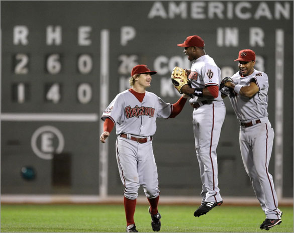 Arizona Diamondbacks rightfielder Justin Upton, center, leaps as he celebrates a 2-1 win over the Boston Red Sox with teammates Eric Byrnes, left, and Chris Young, right, after their MLB baseball game at Fenway Park in Boston, Monday June 23, 2008.