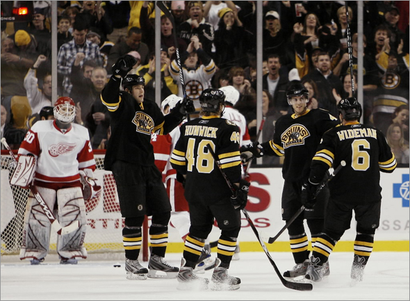 Boston Bruins David Krejci, second from right, of the Czech Republic celebrates his third-period goal with teammates Dennis Wideman (6), Matt Hunwick (48), and Blake Wheeler as Detroit Red Wings goalie Chris Osgood, left, looks on during the Bruins 4-1 win in a hockey game in Boston Saturday, Nov. 29, 2008.