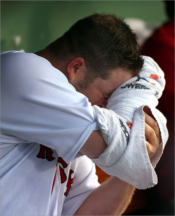 Red Sox starting pitcher Brad Penny wipes his face with the towel that covers his pithing arm in the Sox dugout,  as he enjoys a 3-0 lead in the 3rd inning.