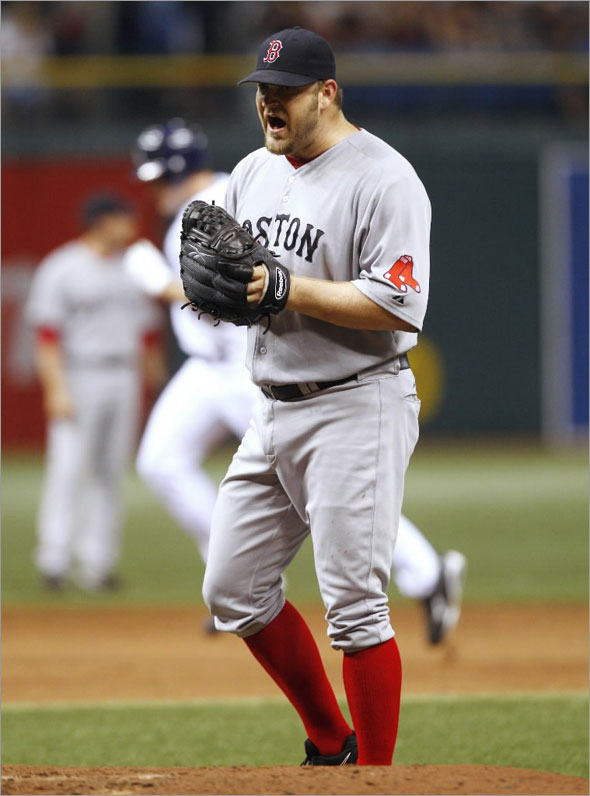 Red Sox pitcher Brad Penny reacts to giving up a home run to the Tampa Bay Rays' Pat Burrell (background) during the sixth inning their MLB American League baseball game in St. Petersburg, Florida August 5, 2009.