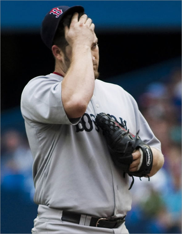 Brad Penny wipes his face during a break in play against the Toronto Blue Jays during the fourth inning of their MLB American League baseball game in Toronto, July 18, 2009