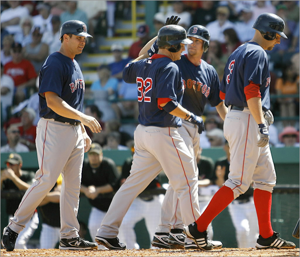 Boston Red Sox' Brad Wilkerson is greeted by teammates Jed Lowrie, Josh Bard, right, and Jeff Bailey,left, after driving them in after hitting a grand-slam home run against the Pittsburgh Pirates in the third inning of the spring training baseball game in Bradenton, Fla., Monday, March 9, 2009. 