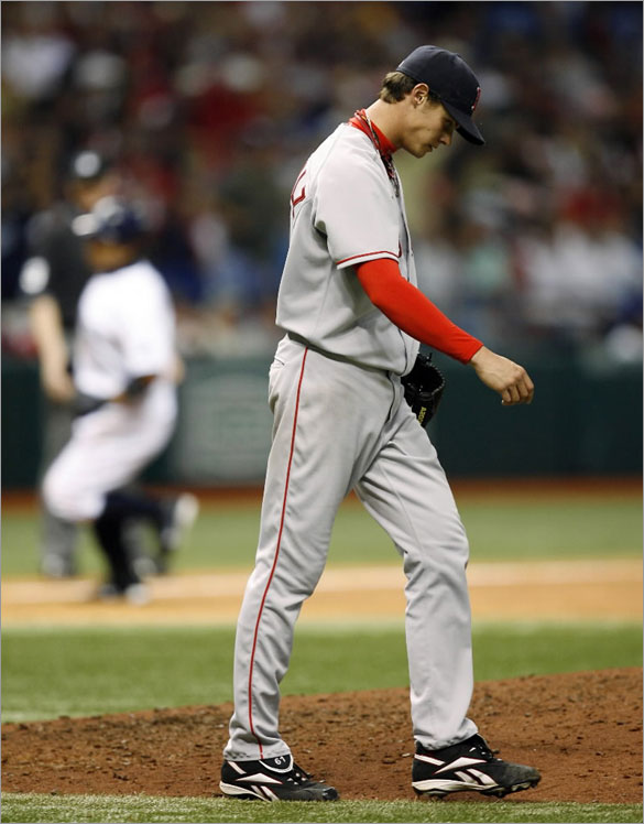 Red Sox starting pitcher Clay Buchholz returns to the mound after giving up an eighth-inning, two-run home run to Tampa Bay Rays' Akinori Iwamura, rounding the bases in the background, during a baseball game Saturday, April 26, 2008, in St. Petersburg, Fla. The Rays won 2-1.