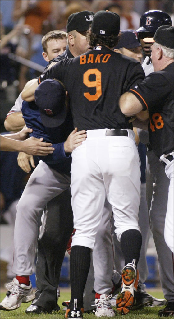 Orioles Paul Bako is held back by Red Sox Curt Schilling after both teams ran on to the field in Baltimore

