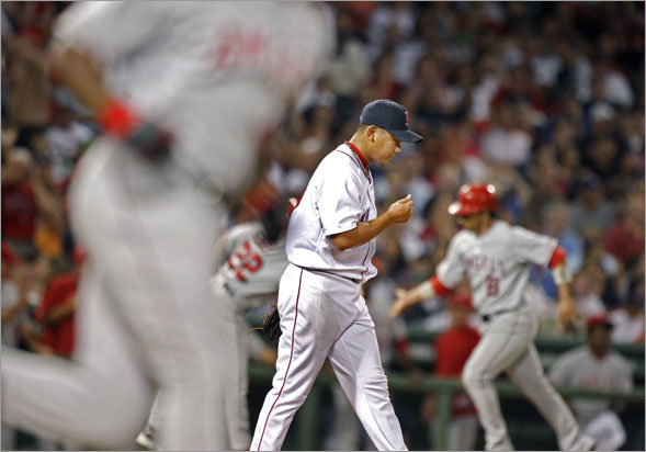 Red Sox pitcher Daisuke Matsuzaka is caught in the middle as the Angels Torii Hunter round first at left, and teammate Maicer Izturis rounds third at right following Hunter's sixth inning three rund home run that spelled the end of the Boston starter's night.  