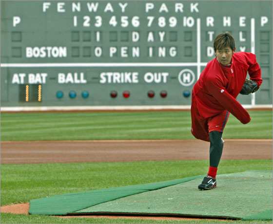 The Sox were given a well earned day off, but that didn't stop opening day starting pitcher (and notorious workout warrior) Daisuke Matsuzaka from showing up at Fenway. He did some throwing and running in the outfield, then, as he was finishing up and headed for the clubhouse, he decided to take a detour and walked out to the mound to check on the condition of the hill. The mound was covered, and the grounds crew was working on the field, so Matsuzaka, without a baseball in his hand (which he had covered by his jersey sleeve to ward off the cold air) took a couple of pretend throws to get the feel of  the mound. The mesage on the Green Monster behind him reads 1 Day Til Opening Day.