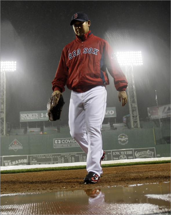 Red Sox pitcher Daisuke Matsuzaka walks into the dugout at Fenway Park after he was scratched as the starting pitcher in their baseball game against the New York Yankees due to the game's delay and the rainy weather in Boston Friday, Sept. 26, 2008 