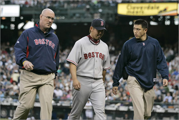 Red Sox pitcher Daisuke Matsuzaka, center, walks off the field with a trainer, left, and his interpreter as he leaves the game at the start of the fifth inning against the Seattle Mariners in their baseball game in Seattle, Tuesday, May 27, 2008