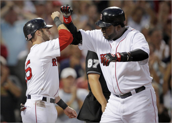 David Ortiz, right, is welcomed home by Dustin Pedroia after Ortiz hit a three-run home run off Texas Rangers' Tommy Hunter in the second inning inning of a baseball game at Fenway Park, in Boston, Thursday, Aug. 14, 2008. The Red Sox won 10-0.