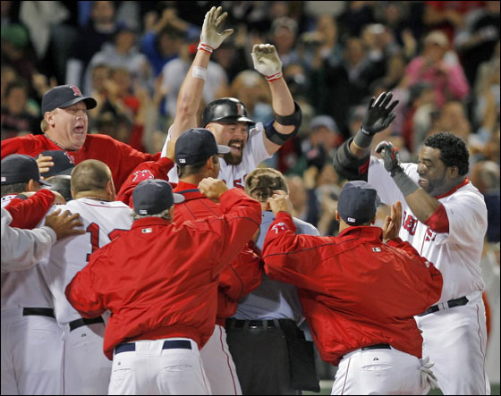 David Ortiz, right, is welcomed home by teammates after hitting a two-run home run off a pitch by Al Reyes in the ninth inning at Fenway Park, Wednesday, Sept. 12, 2007. The two-run home run gave the Red Sox a come from behind win