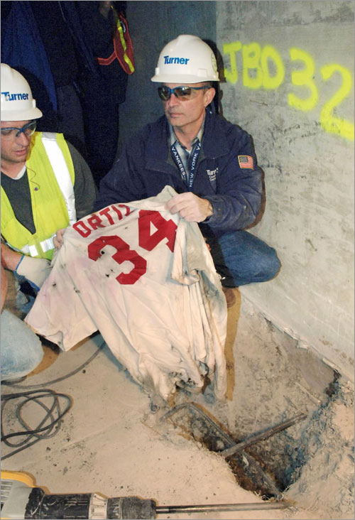 Frank Gramarossa, project executive for the new Yankee Stadium, removes a Boston Red Sox jersey with the name of player David Ortiz from the ground at the new Yankee Stadium in New York, Sunday, April 13, 2008.