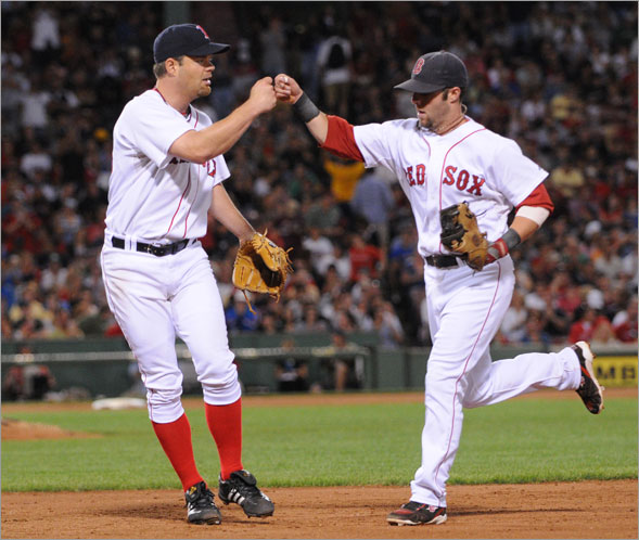Red Sox starting pitcher Paul Byrd gives a fist hit to teammate second baseman Dustin Pedroia during the 6th inning. The Boston Red Sox host the Baltimore Orioles in a MLB game played at Fenway Park in Boston, MA Monday, September 1, 2008.