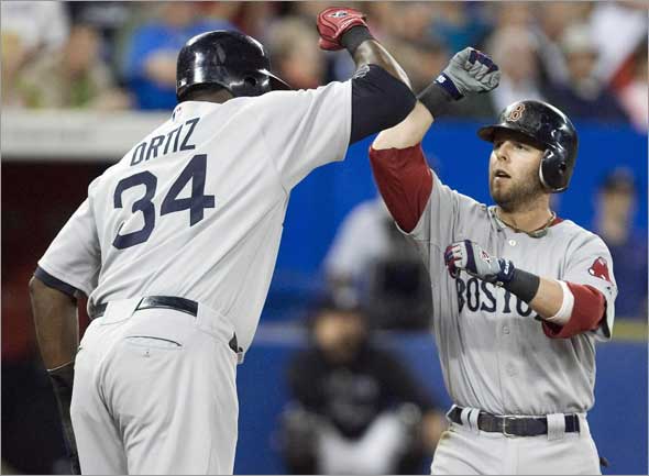 Red Sox second baseman Dustin Pedroia is congratulated by team mate David Ortiz after hitting a three-run home run against Toronto Blue Jays in the fourth inning 