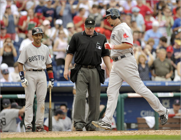 Red Sox starting pitcher Josh Beckett steps on home plate as umpire Brian Runge  looks on after he hit a solo home run off Philadelphia Phillies pitcher J.A. Happ  in the seventh inning