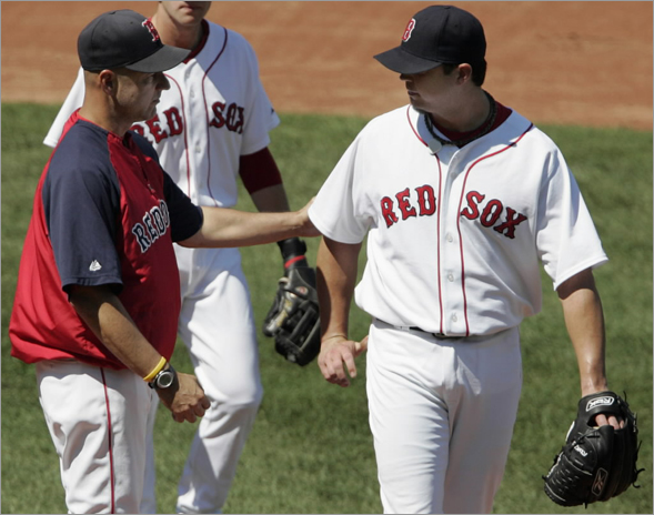 Terry Francona (left) pats Boston Red Sox starting pitcher Josh Beckett on the back as he is taken out of the game during the third inning against the Toronto Blue Jays