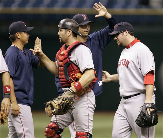 Red Sox pitcher Eric Gagne, right, and catcher Jason Varitek, second from left, gets high-fives from teammates Hideki Okajima, left, of Japan, and Josh Beckett, second from right, after the Red Sox defeated the Tampa Bay Devil Rays, 8-1, during a baseball game Friday night Sept. 21, 2007, in St. Petersburg, Fla. Beckett won his 20th game of the season