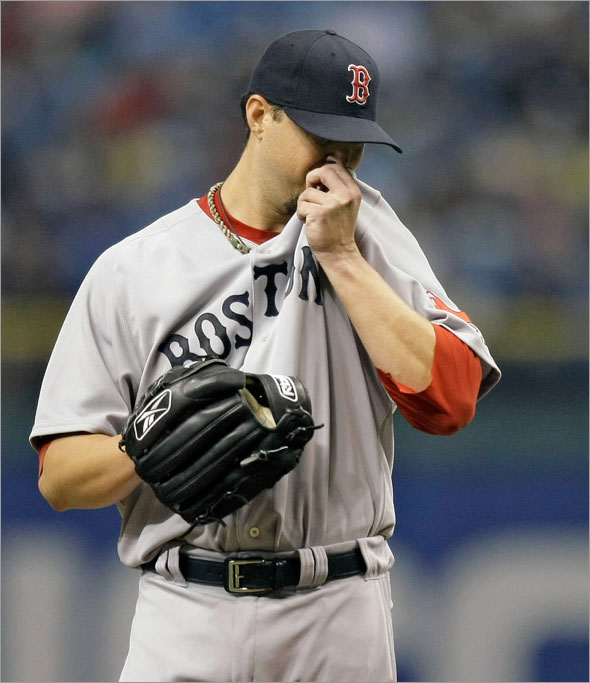 Josh Beckett wipes his face as he struggles against the Tampa Bay Rays during the second inning of a baseball game Wednesday Sept. 2, 2009 in St. Petersburg, Fla. Beckett gave up three runs in the inning.(