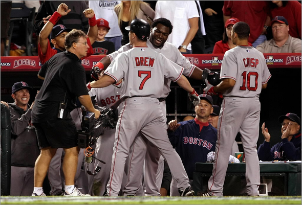 J.D. Drew of the Boston Red Sox celebrates with teammate David Ortiz No. 34 after hitting a two run home run in the ninth inning of game two of the American League Division Series against the Los Angeles Angels of Anaheim at Angel Stadium on October 3, 2008 in Anaheim, California