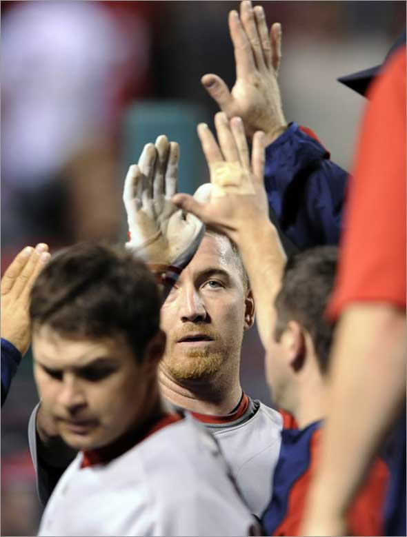J.D. Drew gets high-fives from teammates scoring the go-ahead run on a hit by Jason Varitek against the Los Angeles Angels during the ninth inning of a baseball game in Anaheim, Calif., Tuesday, May 12, 2009.