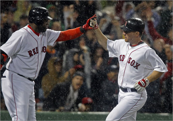 Yankees reliever Alfredo Aceves (backround left), gets a god view as Red Sox DH David Ortiz (center) gives a hand to teammate J.D. Drew (right) as he scores the winning run of the game on a bottom of the eighth inning on a sacrifice fly by Mike Lowell 