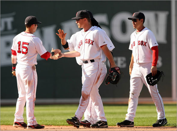 Dustin Pedroia is congratulated by teammates J.D. Drew, Jacoby Ellsbury  and Manny Ramirez after Pedroia made the catch for the final out of the game on July 13, 2008 at Fenway Park in Boston, Massachusetts.