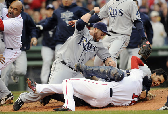 Tampa Bay Rays DH Jonny Gomes cocks his arm as Rays catcher Dioner Navarro  holds Red Sox center fielder Coco Crisp on the ground and in a head lock during the second inning.