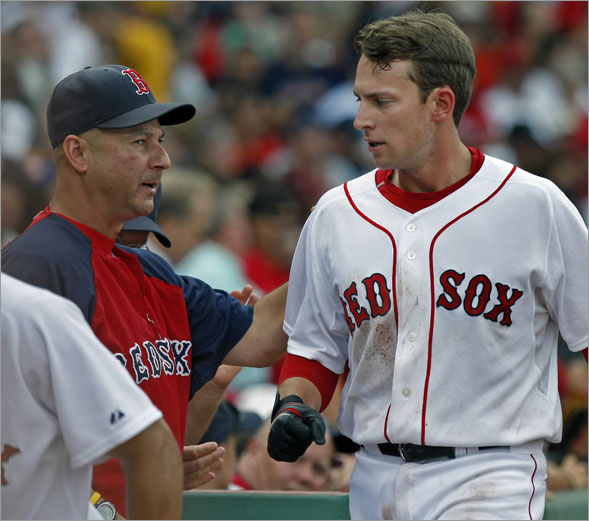 Red Sox manager Terry Francona (left) who had some praise for SS Jed Lowrie (right) during his post game press conference, gives him a hand as he comes into the dugout after scoring in the fourth inning.