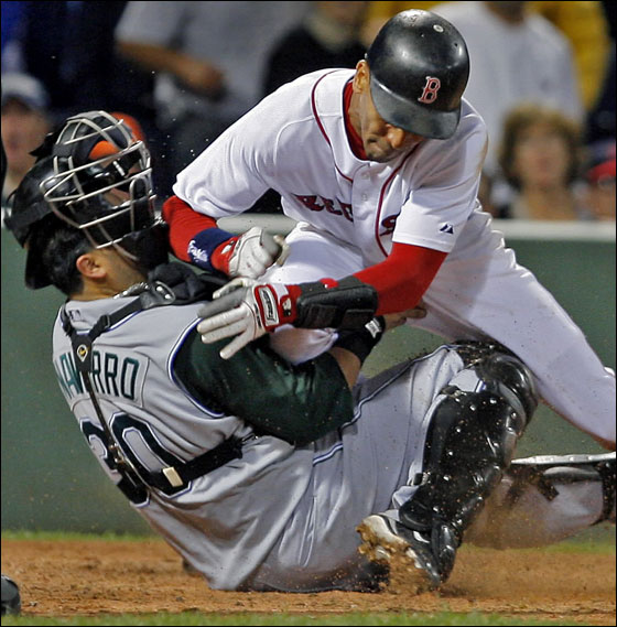 The Red Sox' Julio Lugo slams into Tampa Bay catcher Dioner Navarro as he tags up and scores from third on a fourth inning sacrifice fly by Dustin Pedroia.