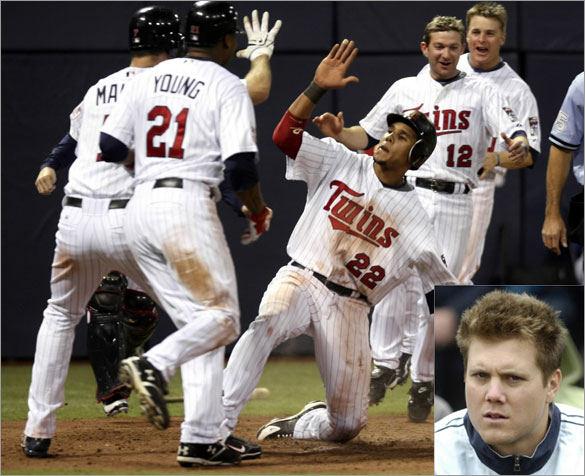 Minnesota Twins Carlos Gomez (22) slides safely into home, and celebrates with teammates Joe Mauer (L), Delmon Young (21) and Adam Everett (12), with the game-winning run after scoring on a hit by teammate Mike Lamb off Red Sox relief pitcher Jonathan Papelbon during the ninth inning