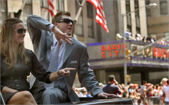 Red Sox closer Jonathan Papelbon, accompanied by his  wife Ashley, shows off his World Series ring to a hostile crowd during a Red Carpet Parade that passed by Radio City Music Hall. Papelbon was loudly booed for initially saying that he, rather than Yankee legend Mariano Rivera should close the All-Star game at Yankee Stadium.