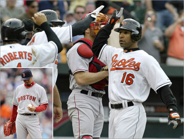 Baltimore Orioles' Jay Payton (16) is greeted at home plate by teammates Freddie Bynum and Brian Roberts (1) after hitting a grand slam home run off of Boston Red Sox relief pitcher Hideki Okajima (below left) in the seventh inning of their MLB American League baseball game in Baltimore, Maryland May 14, 2008