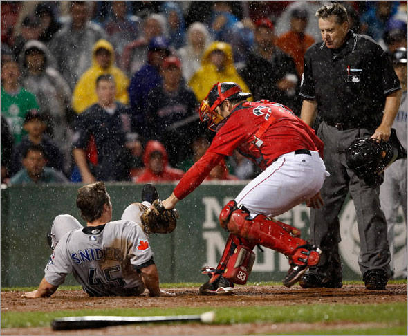 Red Sox catcher Jason Varitek  p[repares to apply the tag to Toronto Blue Jays left fielder Travis Snider (45) who over slid home plate in the 8th inning