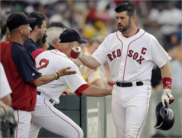 Red Sox manager Terry Francona offers his congratulations to catcher Jason Varitek (33) after his 3-run homer during the first inning. The Boston Red Sox host the Baltimore Orioles in a MLB game played at Fenway Park in Boston