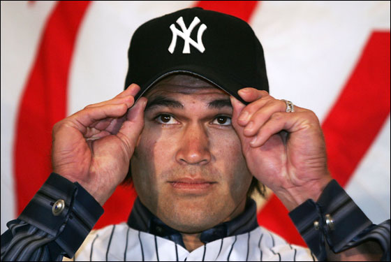Johnny Damon of the New York Yankees tries on his hat after being introduced as the new center fielder on December 23, 2005 at Yankee Stadium in the Bronx Borough of New York City.