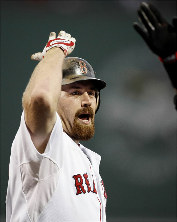 Kevin Youkilis is greeted at home plate by a teammate after the first of his pair of two- run home runs against the Oakland Athletics, during Boston's 12-2 win in a baseball game at Fenway Park in Boston on Saturday, Aug. 2, 2008. 