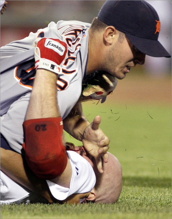 Boston Red Sox's Kevin Youkilis, below, wrestles with Detroit Tigers starter Rick Porcello after being hit by a pitch in the second inning of their baseball game at Fenway Park in Boston, Tuesday, Aug. 11, 2009. 
