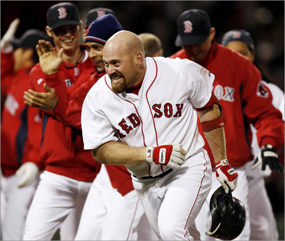 Kevin Youkilis runs for the dugout after being mobbed by his teammates following his game-winning single in the bottom of the ninth inning of their 1-0 win over the Toronto Blue Jays in a baseball game at Fenway Park in Boston Tuesday