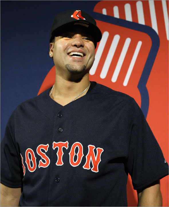 Red Sox baseball pitcher Manny Delcarmen models the new secondary Hanging Sox logo hat and the alternate road uniform jersey during a news conference in Boston Thursday, Dec. 11, 2008. 