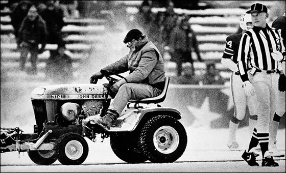 Mark Henderson, 24, a convict on work release from the Massachusetts Correctional Insitution at Norfolk, Mass, clears snow Dec. 12, 1982 at Schaefer Stadium, Foxboro,Mass. Referee Bob Frederic looks on during a third quarter break in action between the New England Patriots and Miami Dolphins. 