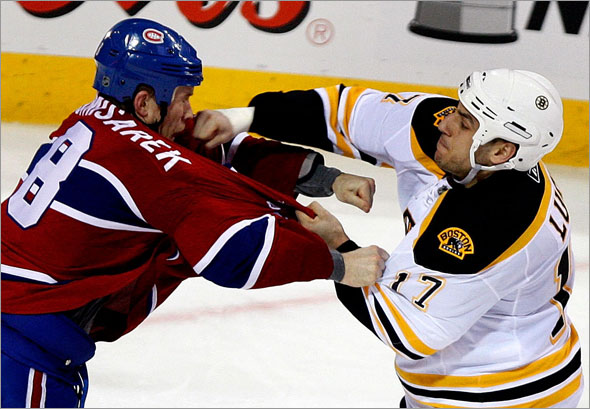 Boston Bruins left wing Milan Lucic  connects with a right to the face of Montreal Canadiens defenseman Mike Komisarek during a fight late in the 2nd period.
