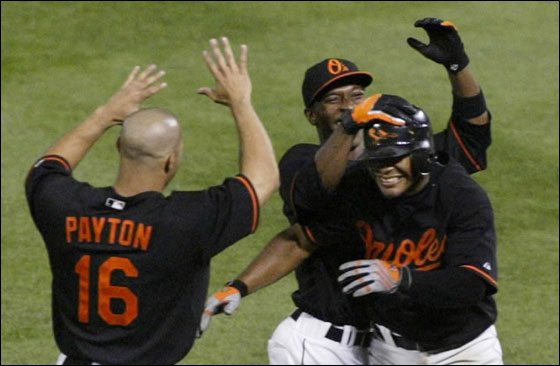Baltimore Orioles' Melvin Mora is greeted by teammates Freddie Bynum and Jay Payton after bunting in the winning run against the New York Yankees in the 10th inning of their MLB American League baseball game in Baltimore,