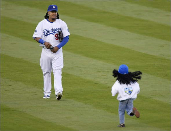 A fan runs out to get an autograph from Los Angeles Dodgers' Manny Ramirez during pre-game activities before Game 4 of Major League Baseball's NLCS playoff series in Los Angeles October 13, 2008.