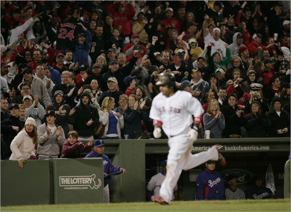 Fans cheer as Boston's Manny Ramirez  heads to home plate after a two run blast to give the Red Sox the lead against Texas during the 8th inning of Saturday's game at Fenway Park
