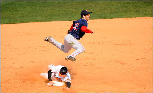 Nick Green of the Boston Red Sox leaps over Ryan Freel of the Baltimore Orioles trying to turn a double play during a spring training game at Fort Lauderdale Stadium on March 2, 2009 in Fort Lauderdale, Florida. 